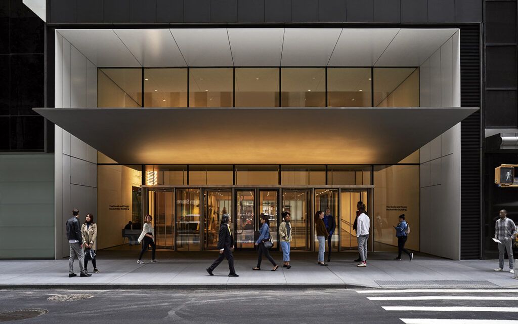 Modern building entrance with people walking outside.